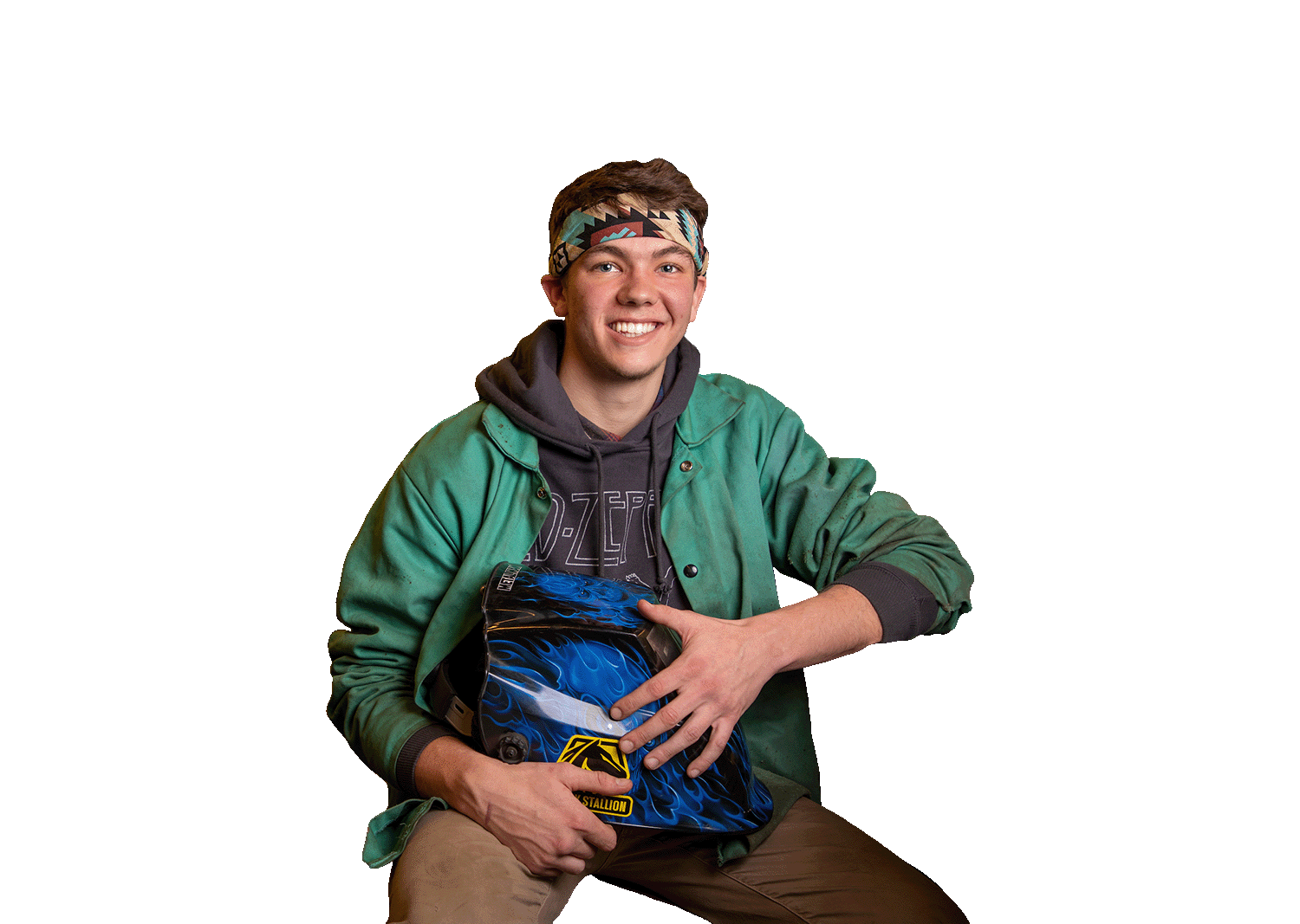 A welding student holds his helmet and smiles