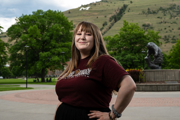 Daylee smiles for a portrait wearing University of Montana apparel in front of the grizzly bear statue along the Oval on the University of Montana campus in Missoula, MT.