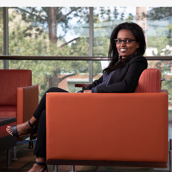 Graduate student sits for a photo in Education Center lounge