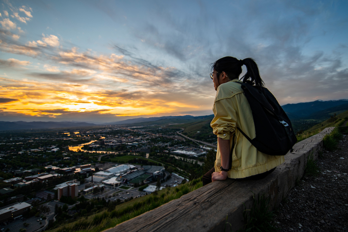 A student looks out a the Missoula Valley from Mount Sentinel
