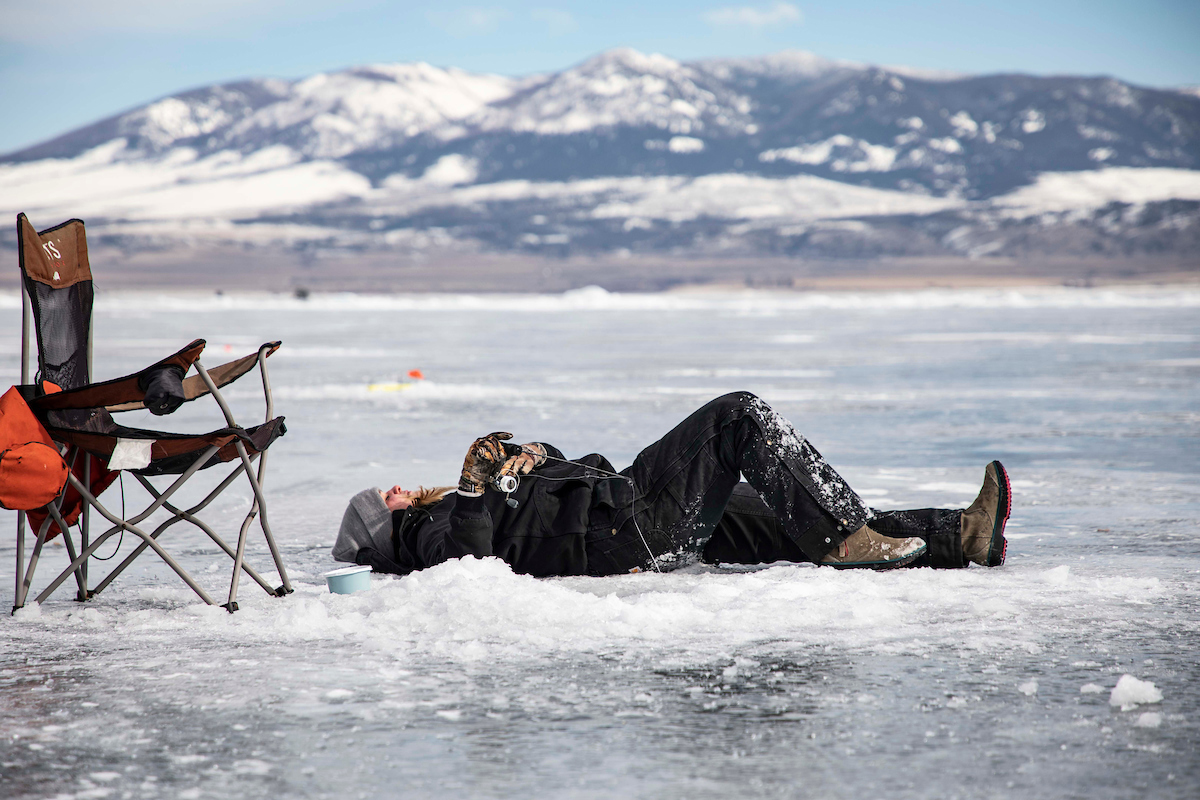 A student takes a rest while ice fishing