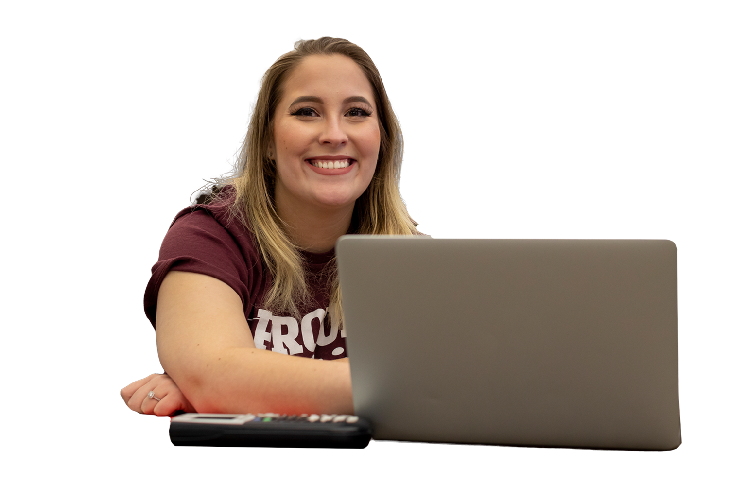 student in a maroon shirt sitting at a table with their laptop on the table