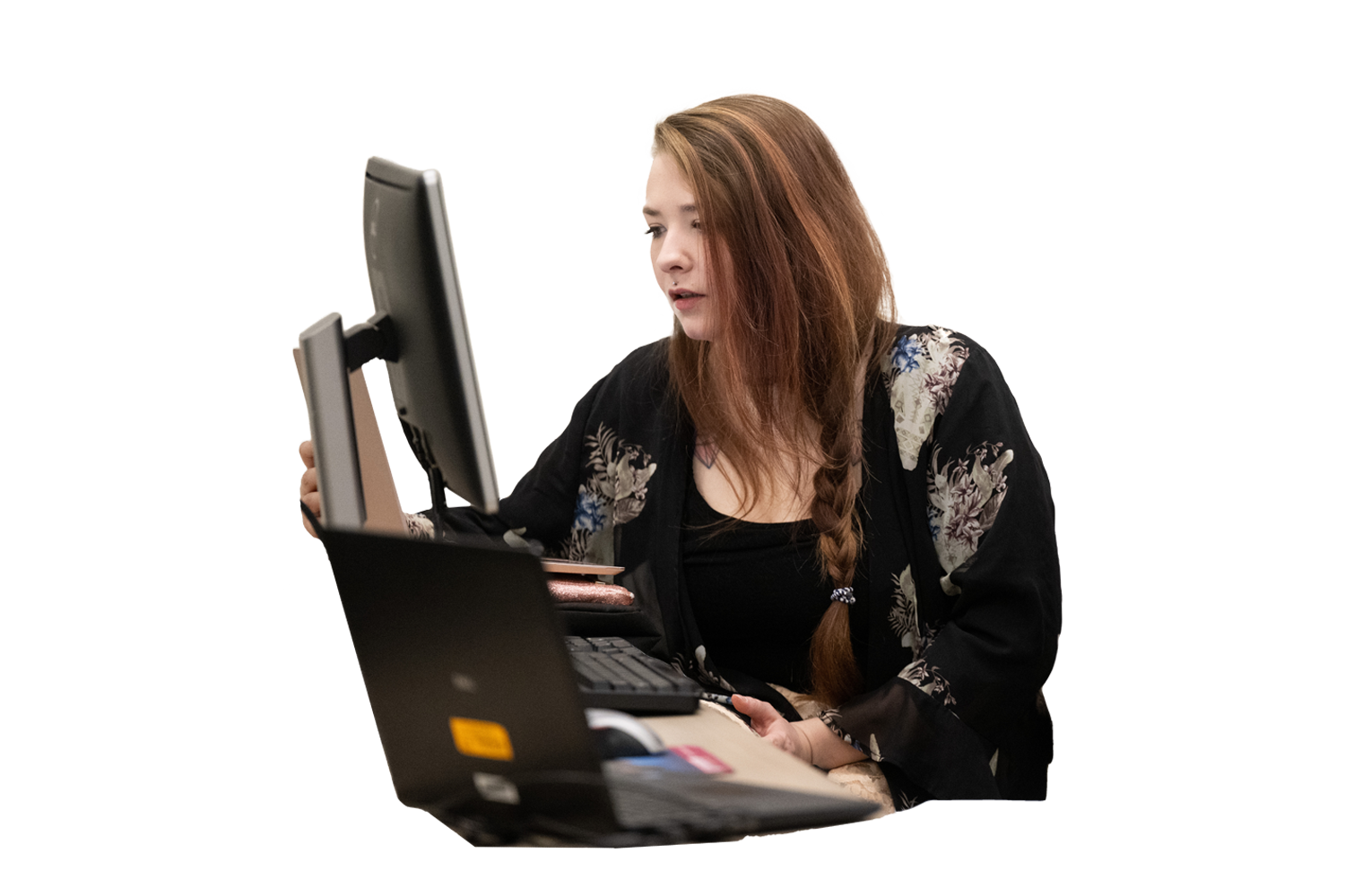 student sitting and focusing on a flat screen computer monitor and reviewing notes